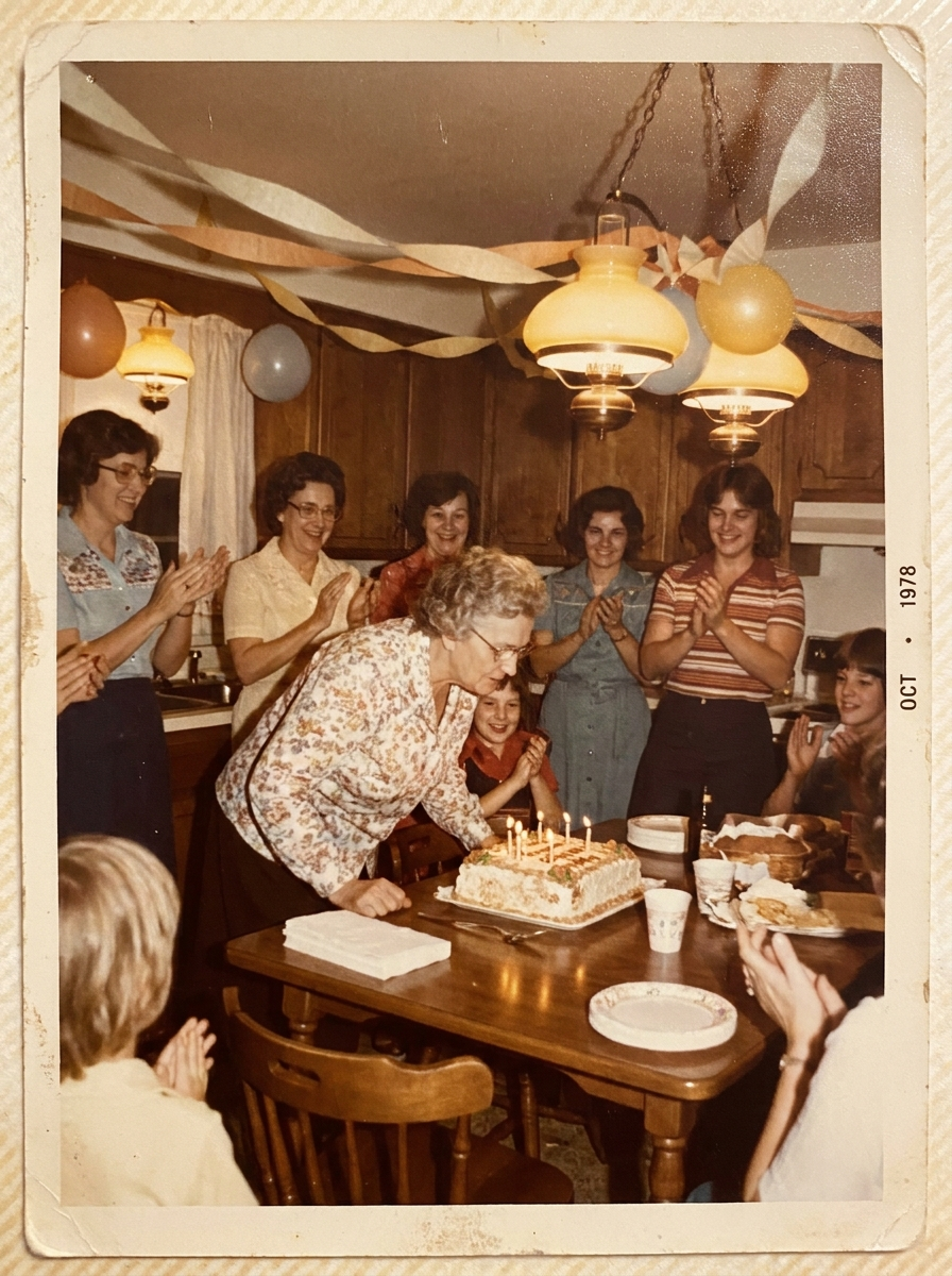 Grandmother blowing out birthday candles as family cheers